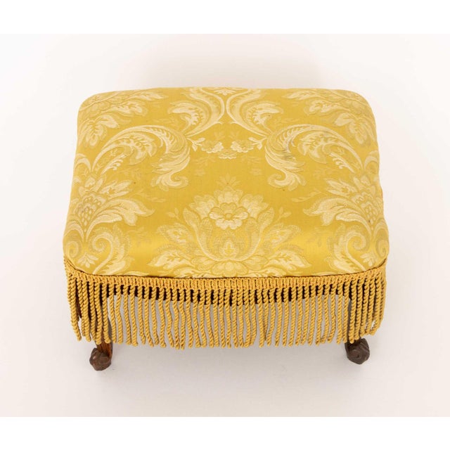 Louis XV Style Yellow Damask Upholstered Ottoman, with fringe tassels and carved walnut cabriole legs. 11" H x 15.5" W x...