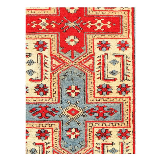 This wool, handwoven vintage Turkish rug features a traditional, intricate design with a wide border, and displays a...