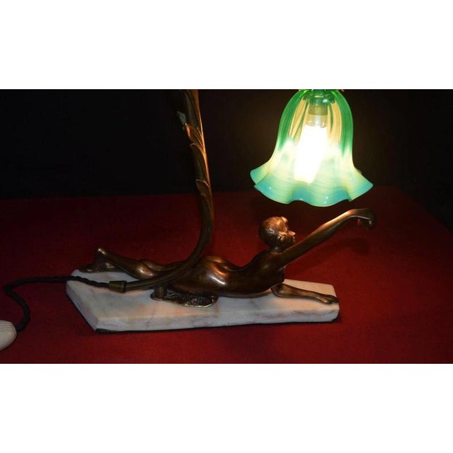 A striking french art deco figural table lamp dating to circa 1930, combining sculptural gilt-bronze metalwork with a...
