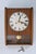 A beautifully preserved vintage mechanical pendulum wall clock housed in a warm teak wood case with softly curved side...