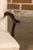 An English wooden child's chair from circa 1900 with serpentine arms, stretchers and custom linen upholstery. This English...