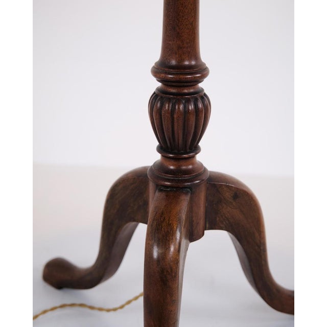 Floor lamp with integrated lamp table made in mahogany in the style of late Empire from the 1880s. The lamp features a...