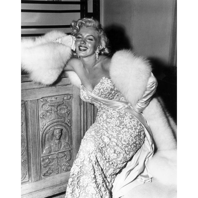 Marilyn In Lace 1953: American actor Marilyn Monroe (1926 - 1962) smiling as she sits at the home of director Jean...