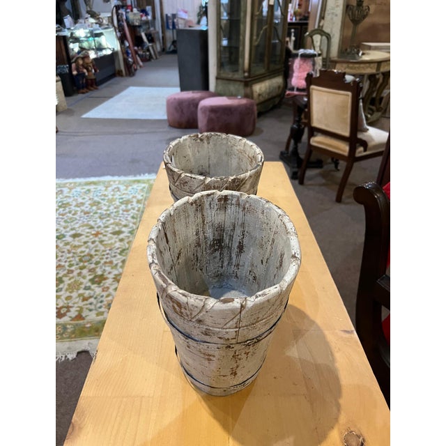 Charming pair of vintage wooden planter buckets featuring beautifully aged paint and hand-crafted construction. The pieces...