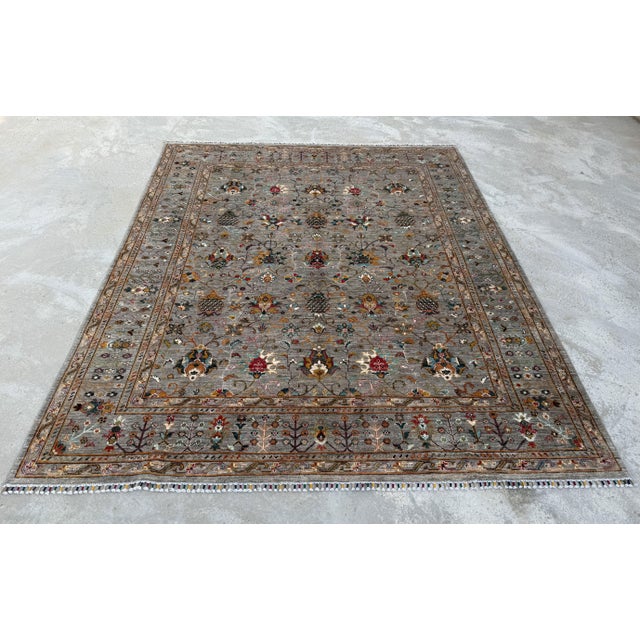 A hand-knotted area rug in the Sultanabad design, worked on a soft silver-grey ground with an allover garden pattern in...