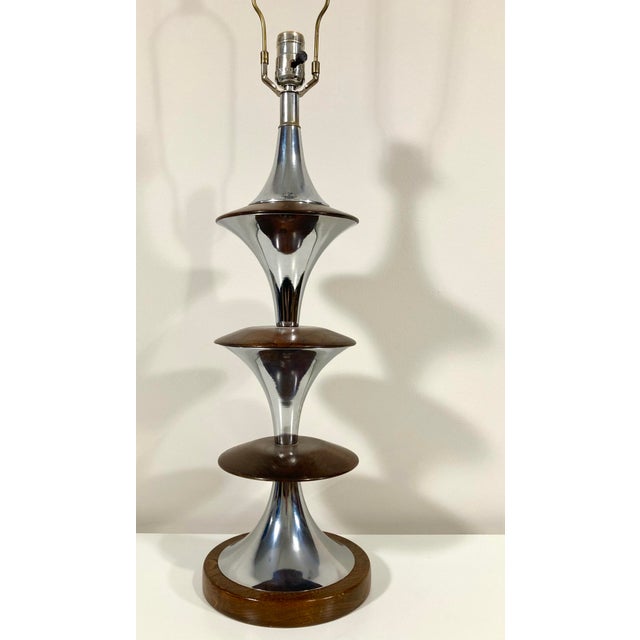 Turned walnut with beautiful grain alternating with fluted chrome elements. Very nice condition. . Measures 36" high to...