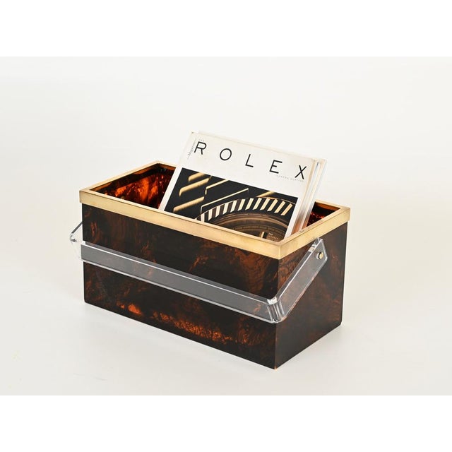 Stunning Mid-Century magazine rack made in a wonderful tortoiseshell effect lucite with a brass rim and a clear lucite...