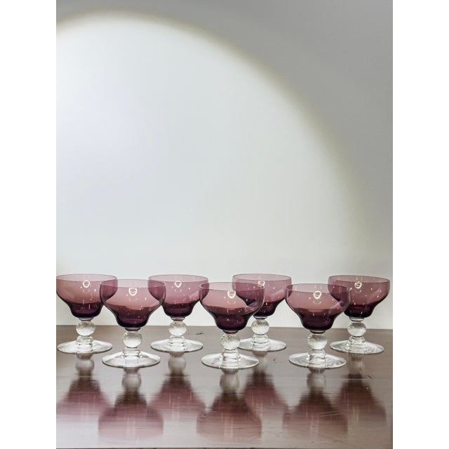 A set of seven vintage French wine glasses, each with a delicate purple twist rising through clear glass. Compact at 3.25"...