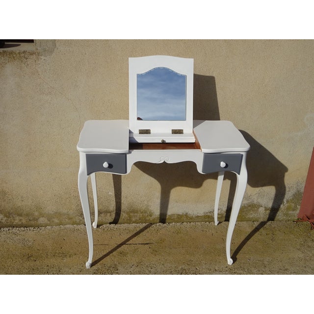 A 1970s dressing table in solid wood, restored and painted white. The central section opens to reveal a mirror on a...