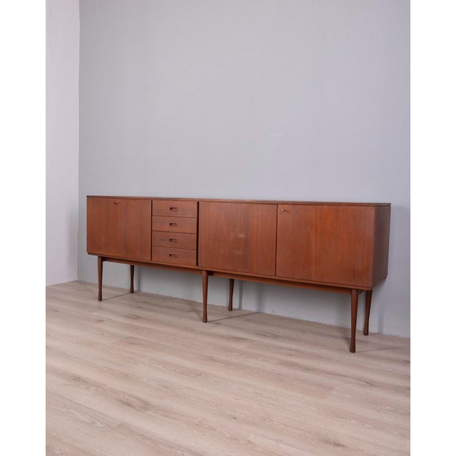 Teak wood sideboard with central drawers, a drop-leaf door on the left and two hinged doors on the right, both with locks,...