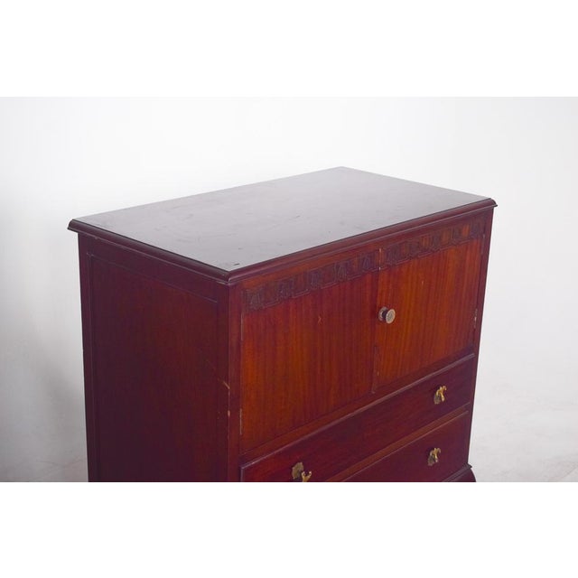 Queen Anne style cabinet. with two doors and two drawers, the straight, compact structure is softened by the cabriolet-...