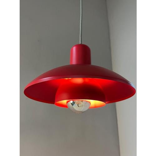 This Horn 728 pendant lamp is a striking piece of lighting from Denmark, distinguished by its vibrant red color and...