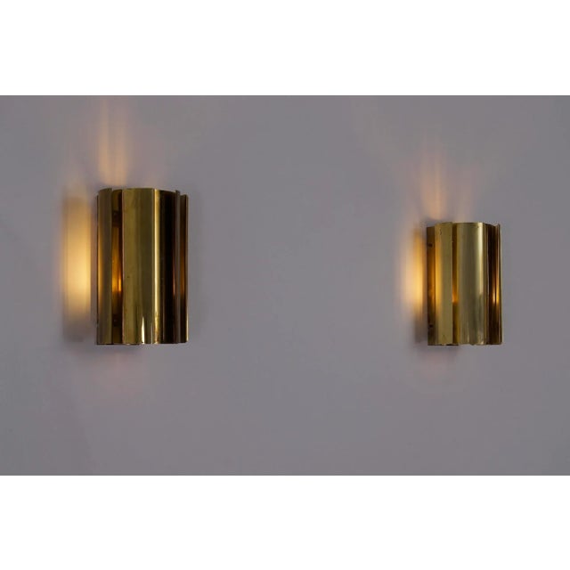 Pair of solid brass wall sconces with offset fins, Swedish work from the 1960s. The deconstructed cylindrical...
