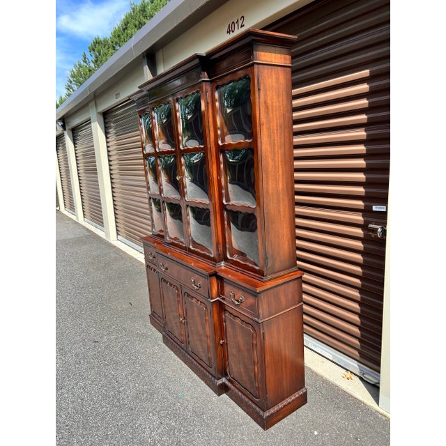 This bookcase features individual panes of bubble glass, drop front writing desk surface with red tooled leather top and...