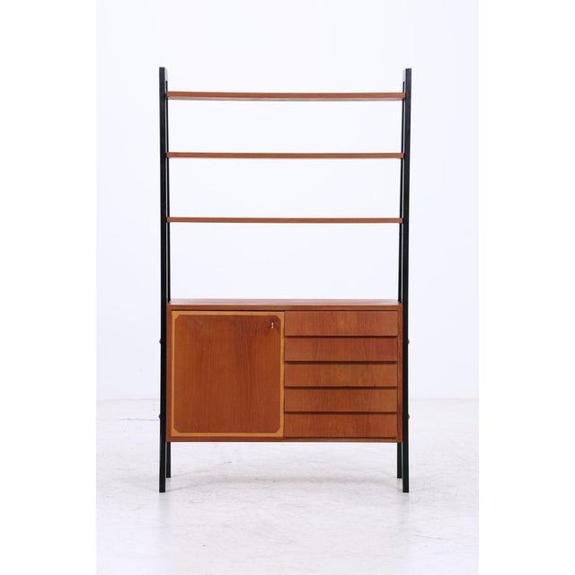 Vintage teak shelving unit with generous open shelves and integrated storage. The lower section combines a door with five...