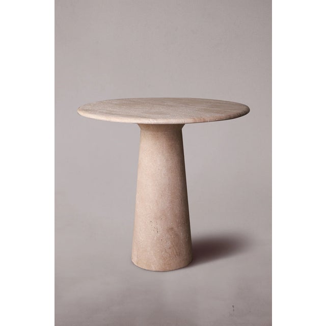 Our travertine dining table features a sturdy pedestal base and a round tabletop, exuding timeless elegance and...