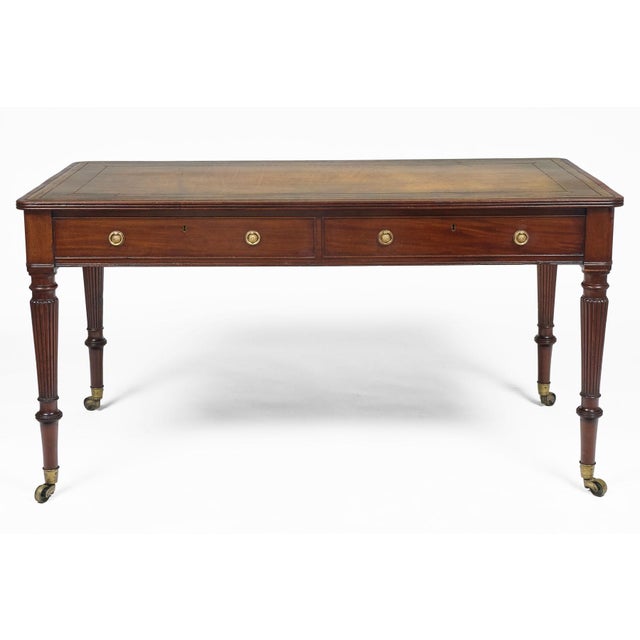 Regency period mahogany writing table with olive green gilt tooled leather surface, reeded top edge, two drawers to the...