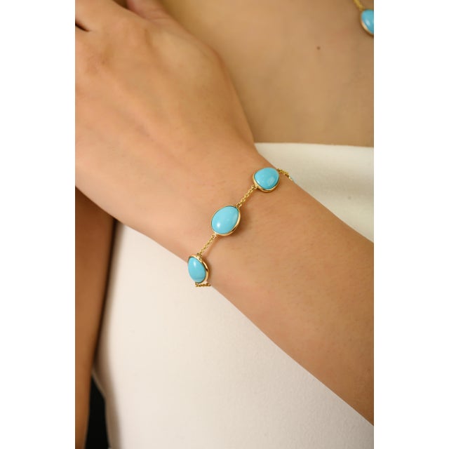 This elegant bracelet features 7 natural turquoise cabochons totaling 13.7 carats, arranged in a solid 14K yellow gold....