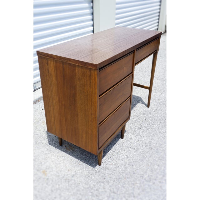 A Mid Century Modern walnut writing desk, attributed to Stanley Furniture Co, featuring clean lines and timeless design....