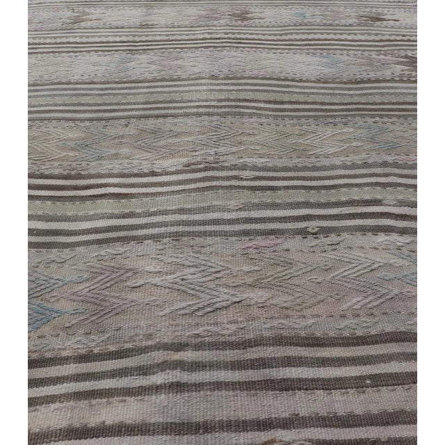 Vintage flat-weave Kilim with embroideries with a modern design in tan, brown, green and blue geometric stripe design....