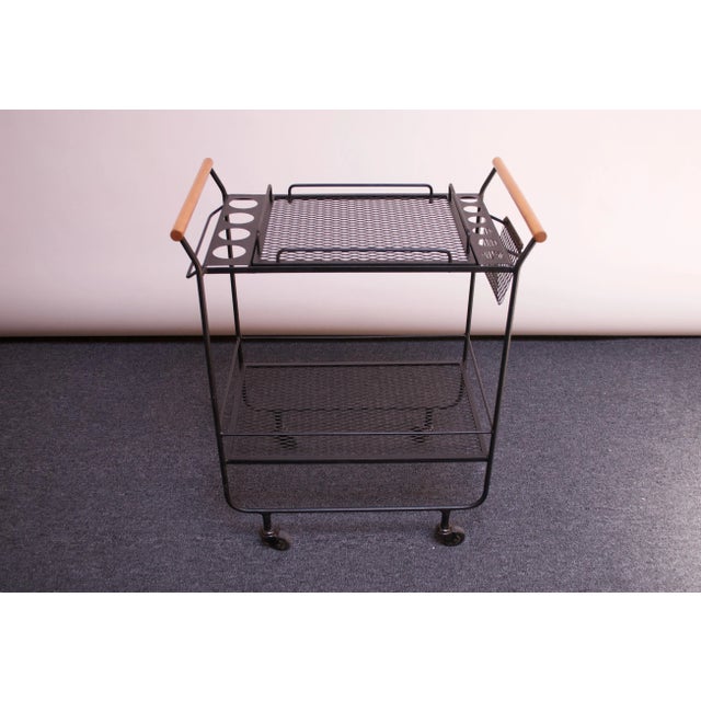 Minimal, modernist bar cart / tea trolley featuring two perforated iron surfaces with four larger glass holders on one...