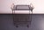 Minimal, modernist bar cart / tea trolley featuring two perforated iron surfaces with four larger glass holders on one...