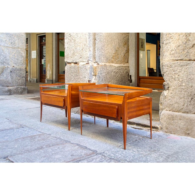Pair of teak bedside tables with glass tops. Designer: Gio Ponti Manufacturer: La Permanente Mobili Cantù 1960s This piece...