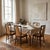 Six elegant 1950s dining chairs with wooden frame finished in polyester, seat and backrest with skai upholstery, brass...