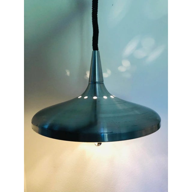 Vintage, mid-century, space age, industrial-style, rise and fall pendant lamp in the shape of a flying saucer, made of...