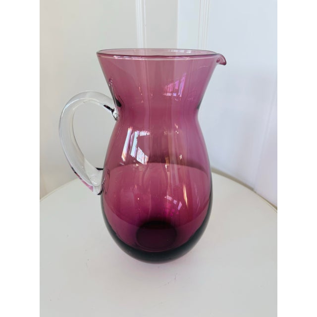 Mid-century modern amethyst glass hand blown pitcher. The unique purple hue of amethyst glass is achieved through the...