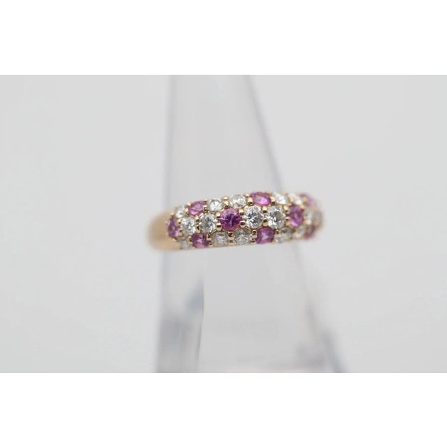 A simple yet stylish gold band featuring fine pink sapphires and diamonds! The diamonds weigh a total of 0.66 carats and...