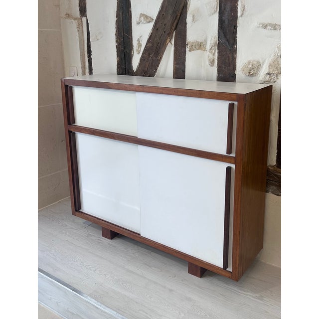 Sideboard with sliding doors. Mahogany frame with white melamine finish. Designed by Le Corbusier for the "Cité Radieuse"...