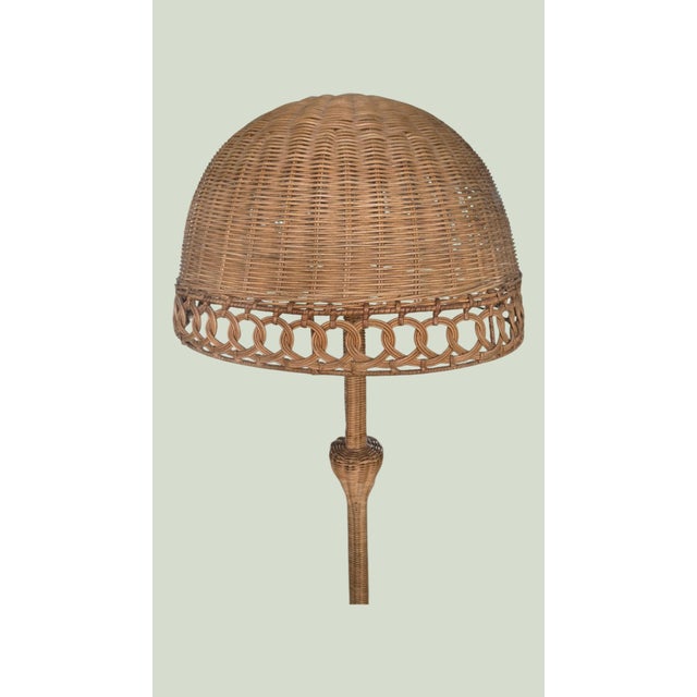 This Vintage Rattan floor lamp featuring an oversized dome-shaped wicker shade with an elegant open fretwork border and...