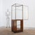Art Deco corner display cabinet in wood and glass, with a rounded nickel-plated brass frame on the front. The upper glass...