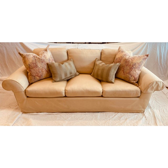 A vintage A.Rudin silk upholstered three seat sofa rolled arms dressmakers skirt loose back & seat cushions with four...
