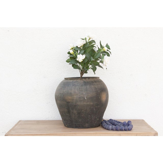 Featuring a beautifully weathered gray finish, this large vintage pottery vase stands out with its rounded silhouette and...