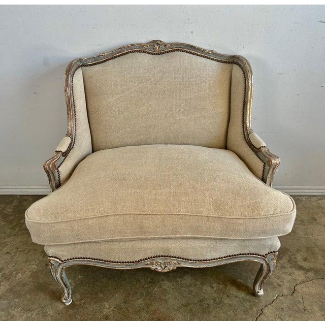 early 20th century French Louis XV style oversized carved wood Bergeres. The armchair painted blue with silver gilt...