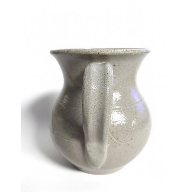 A handsome signed studio pottery pitcher by North Carolina potter M.L. Owens, representing the rich pottery tradition of...