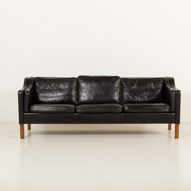 This 3 seater luxurious black leather sofa was made by mogens hansen in denmark in the late 1970s and is a refined example...