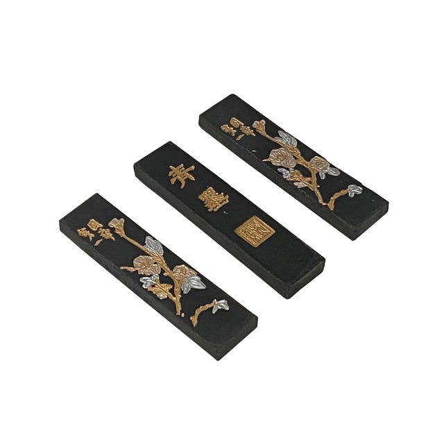 This is a set of 3 Chinese calligraphic black color ink sticks which have two-sided motifs. One side is carved with a...