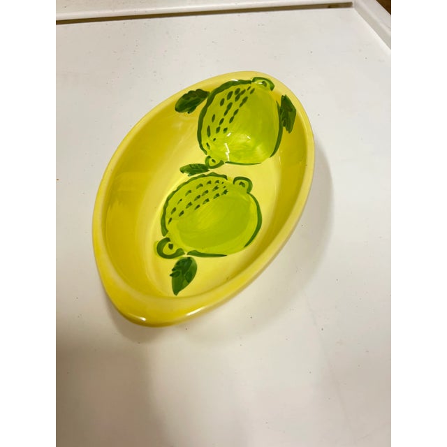 Bright Yellow oval dish. Marked made in Italy on the bottom. 2 Green circular object painted on the bottom of the dish. I...
