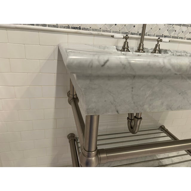 Substantial Bathroom or laundry room sink in solid carrara marble. Sink is carved into the stone and is supported with...