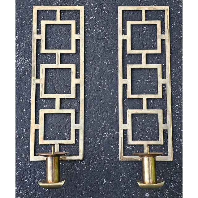 A Pair of 20th Century Chinoiserie Brass Candles Sconces Measures 37" in width x 18" in depth at the base x 41.5" in height.