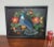 Colorful mid century embroidered peacock surrounded by flowers on a black ground. Protected in a shadowbox frame and ready...