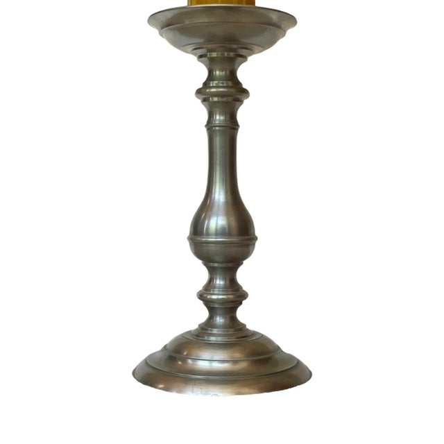 A classic pewter candlestick fitted with a substantial faux wax-drip sleeve and finished by an original shade accented in...