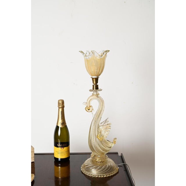 Marvelous swan-shaped sculptural table lamp entirely made in a gorgeous murano blown glass with 24k gold inside. This...