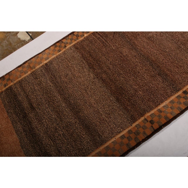 Hand knotted in wool originating between 1950-1960, this mid-century Persian rug joins the latest Gabbeh rug additions to...
