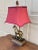 A gorgeous English Country style equestrian lamp featuring a horse and a cranberry colored fabric shade USA, 21st Century...