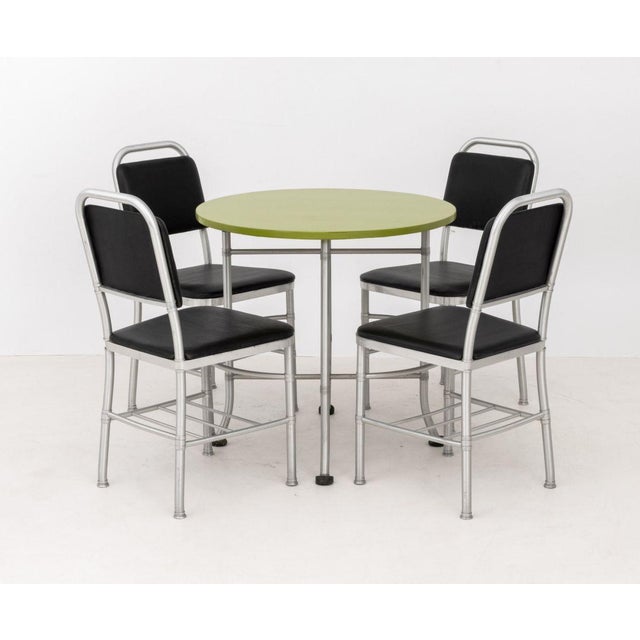 Warren McArthur (American, 1885-1961) Art Deco Cafe Table and Four Dining Chairs, circa 1933, aluminum, lacquered wood and...