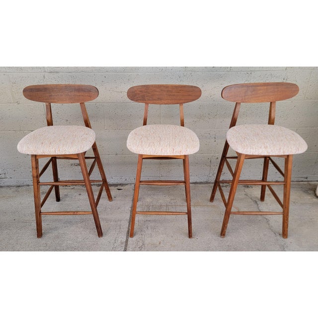 A set of 3 Mid-Century Modern counter top stools. Classic modern design with oval seat backrest. Made of solid walnut....